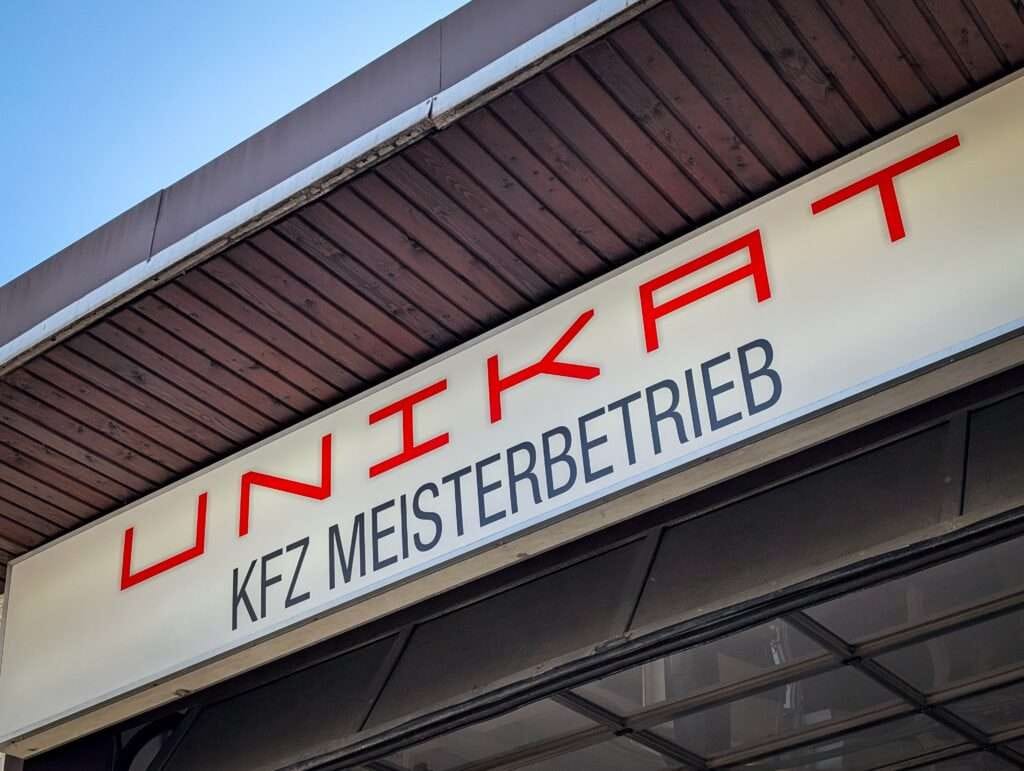 Schild „UNIKAT Kfz Meisterbetrieb“ am Werkstatteingang